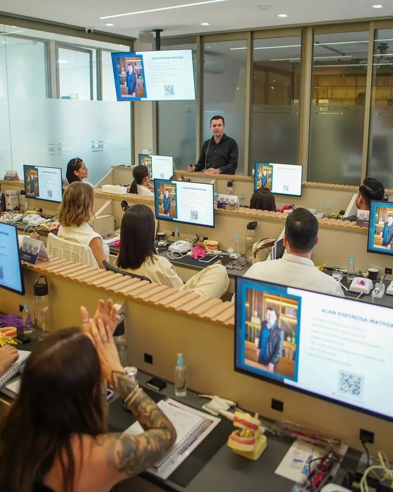 Professor e alunos em aula presencial nas bancadas da EME Academy
